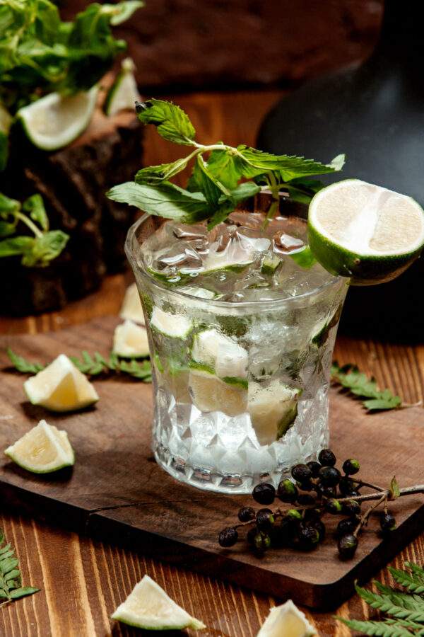a crystal glass of mojito drink garnished with lime slices
